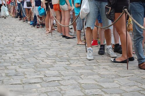 Pessoas aguardando em uma fila de espera, alusão a fila de espera do Nubank que acaba de ser extinta. 